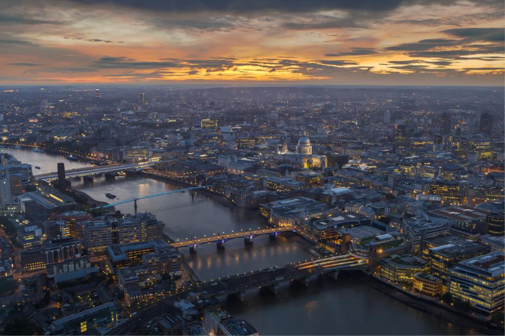 An aerial photo of London showing part of the River Thames with St Pauls in the middle ground. Taken at sunset.